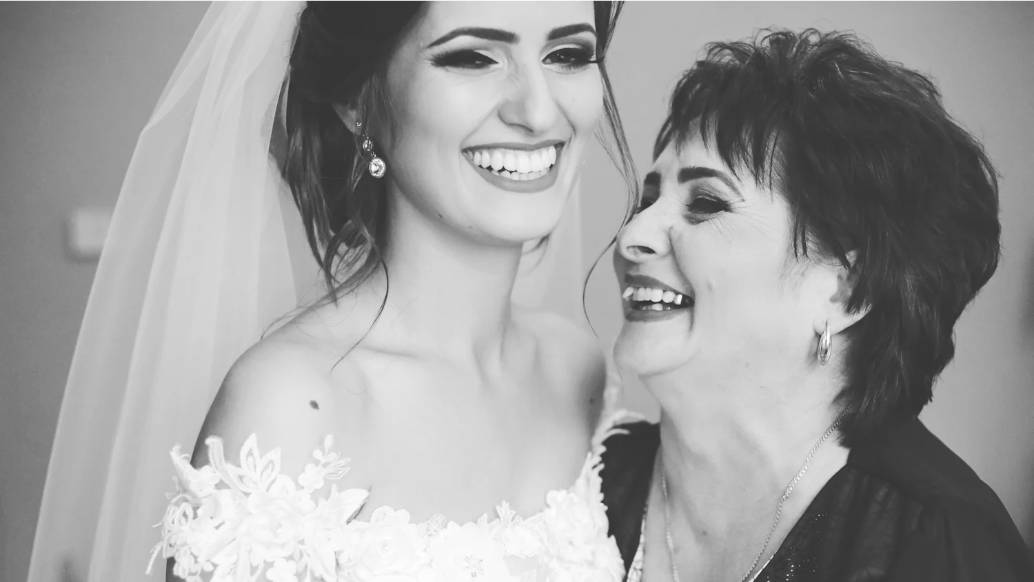 Une mariée et sa mère qui rient ensemble, front contre front