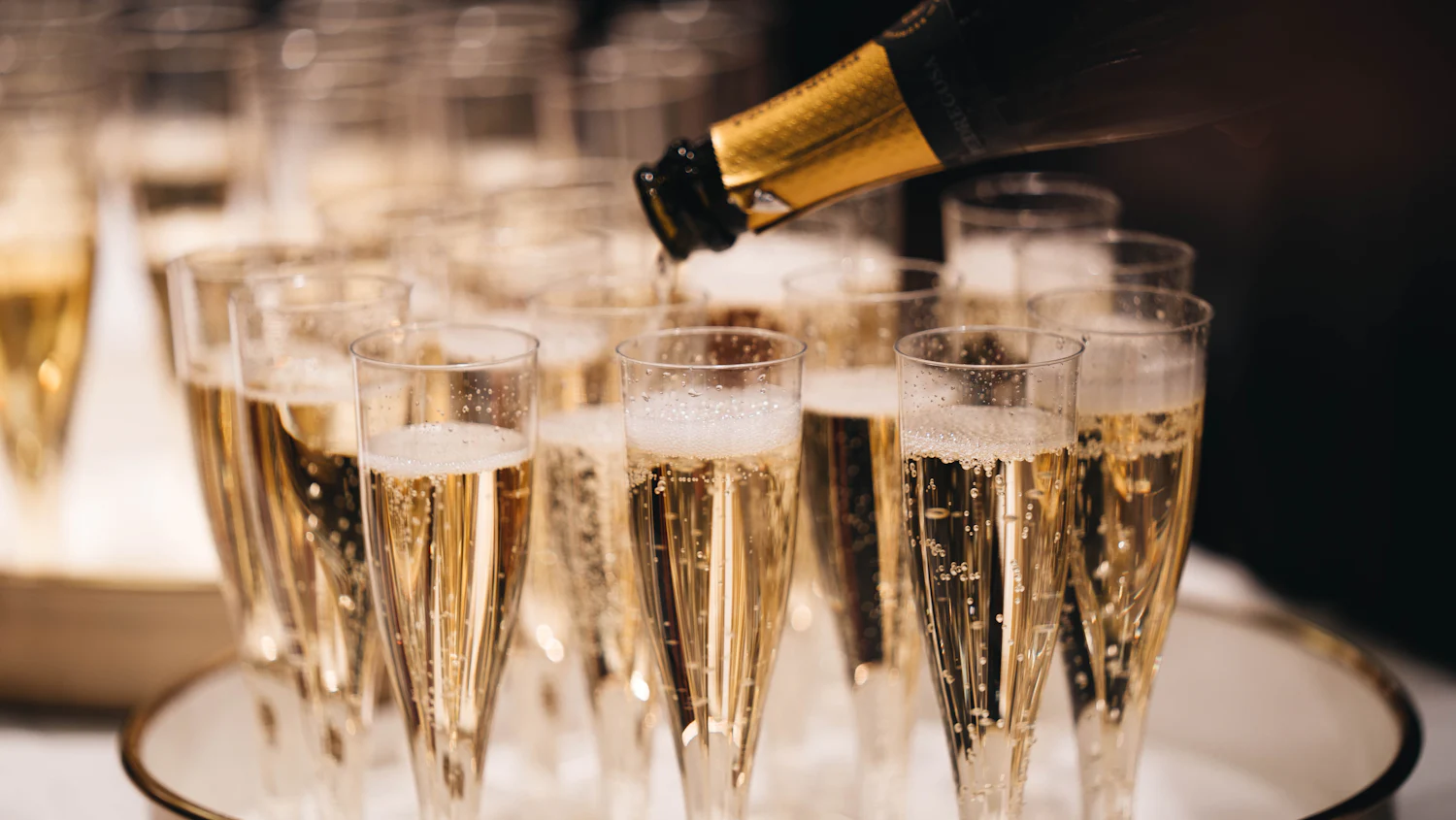 Du champagne versé dans une rangée de flûtes