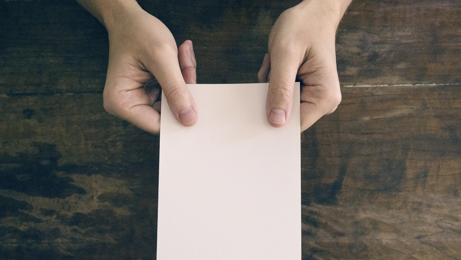 Deux mains qui tiennent une feuille de papier